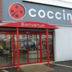 supermarché coccinelle avec portes en verre et voiture garée dans le parking